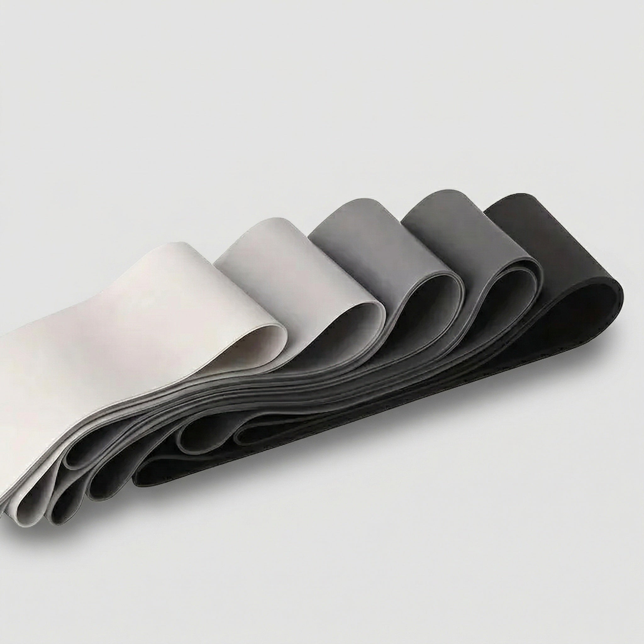 Set of gray and black resistance bands on a light gray background